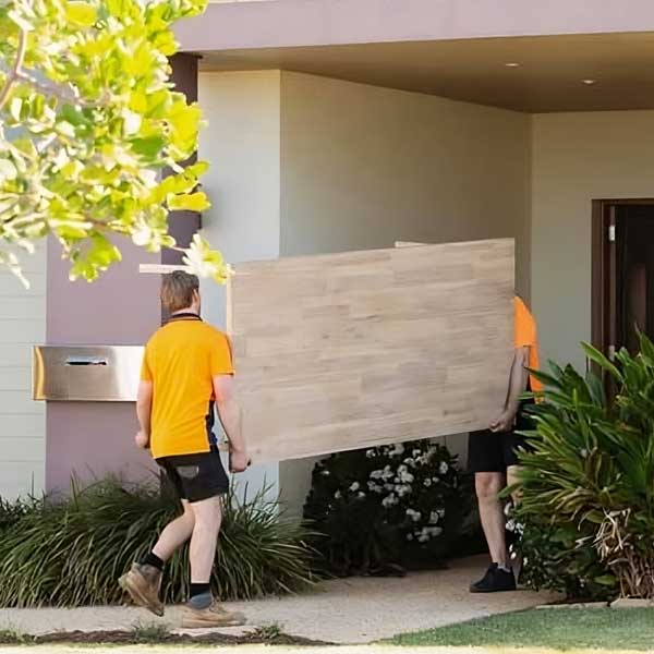 Two Men Carrying A Large Wooden Table — Easy Choice Removals & General Freight in Raymond Terrace, NSW